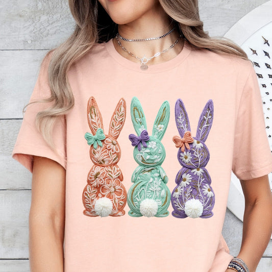 Person wearing a peach t-shirt with decorative bunny rabbits and snowballs design.