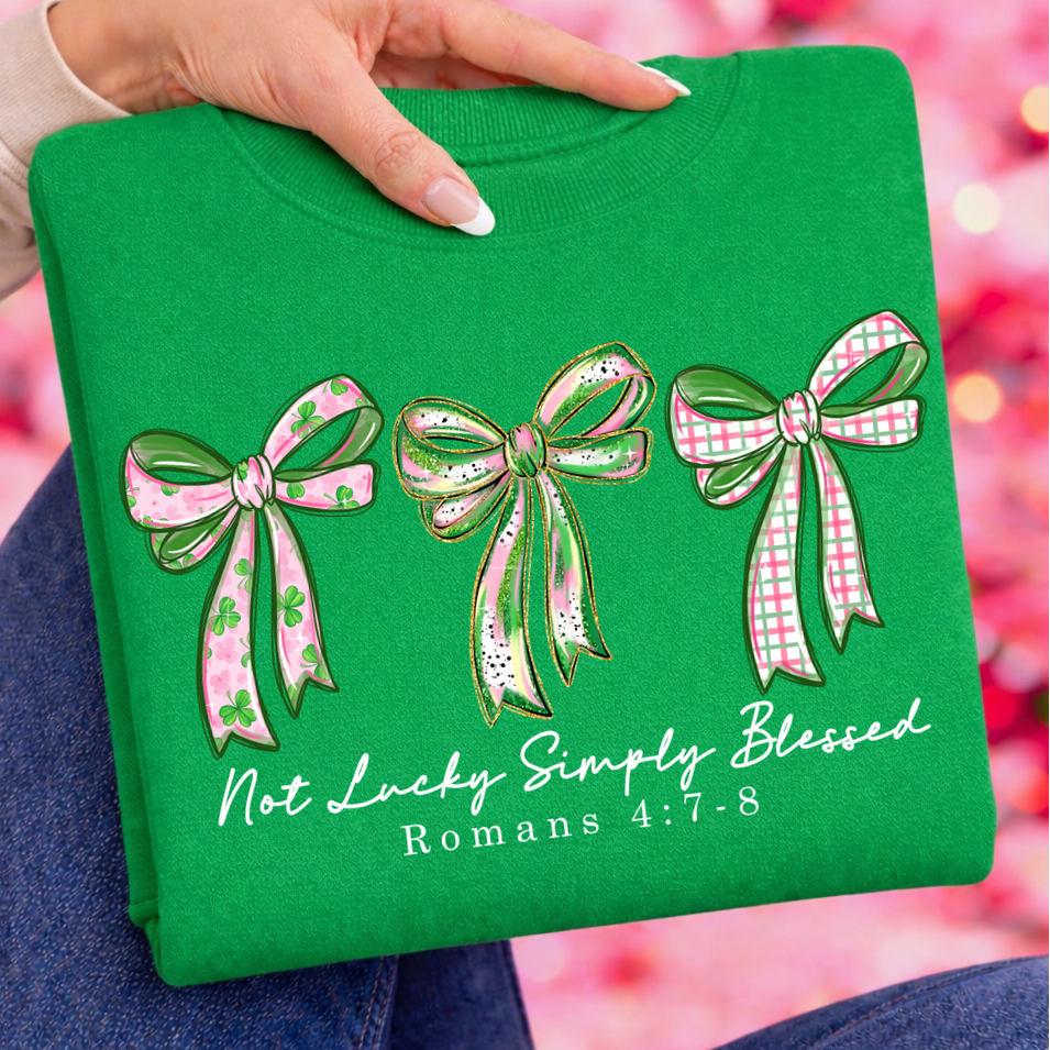 Green shirt with decorative bows and text held by a person against a blurred background