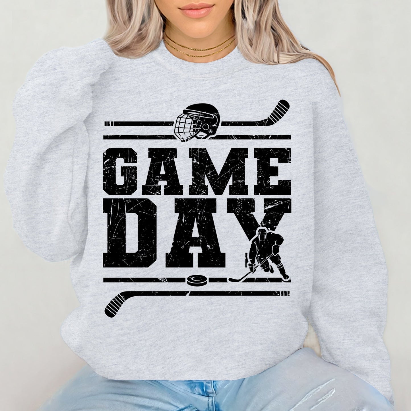 Person wearing a light gray sweatshirt with 'GAMEDAY' and hockey graphics.