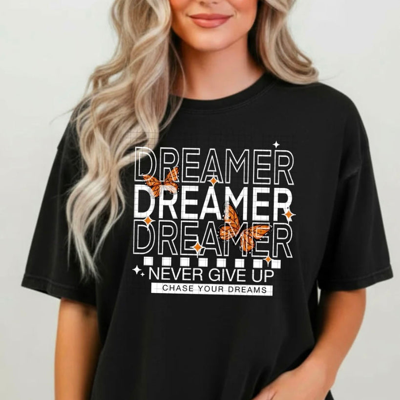 Person wearing a black t-shirt with motivational text and designs.