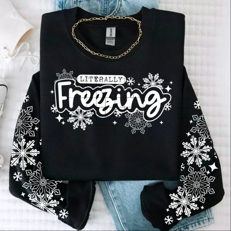 Black sweatshirt with 'Literally Freezing' text and snowflake designs on a white background