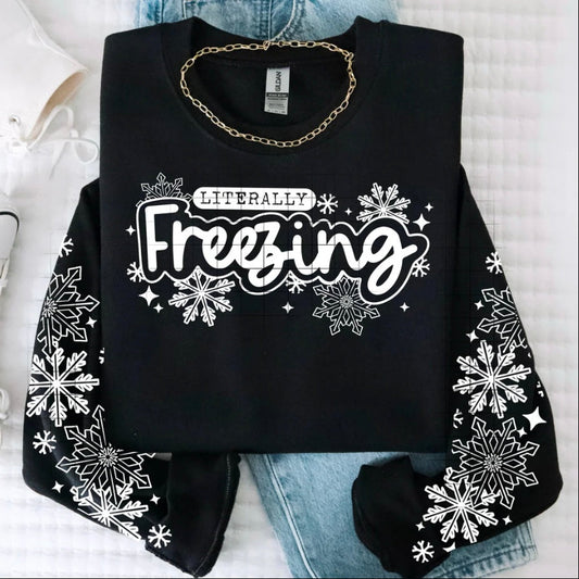 Black sweatshirt with 'Literally Freezing' text and snowflake designs on a white background