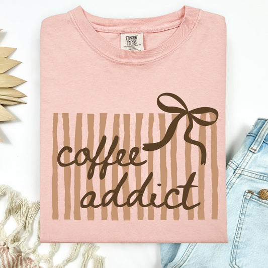 Pink t-shirt with 'coffee addict' text and bow design on a white background