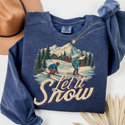 Blue sweatshirt with skiing graphic and 'Let it Snow' text on a white background