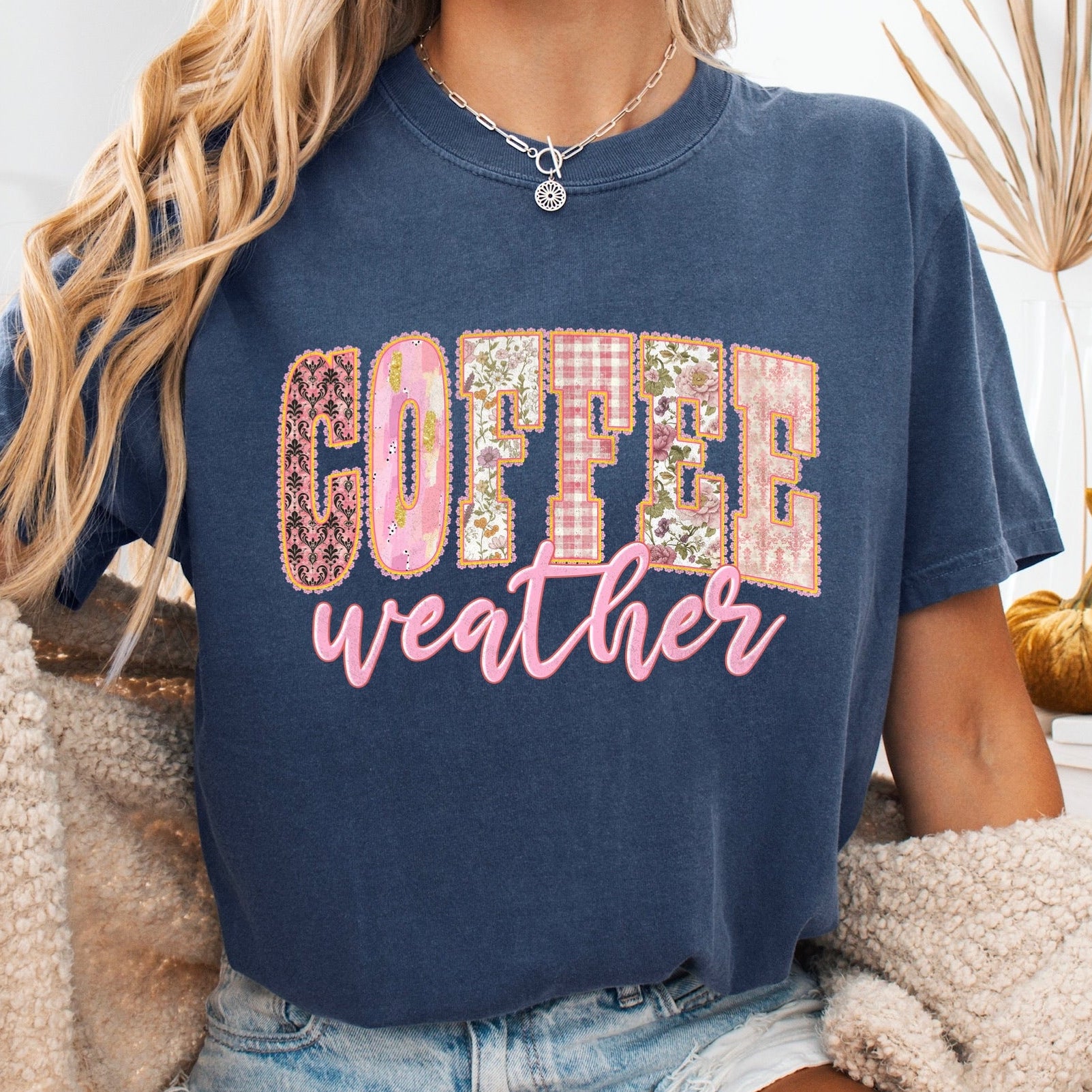 Person wearing a navy blue t-shirt with 'Coffee weather' text, sitting on a couch.