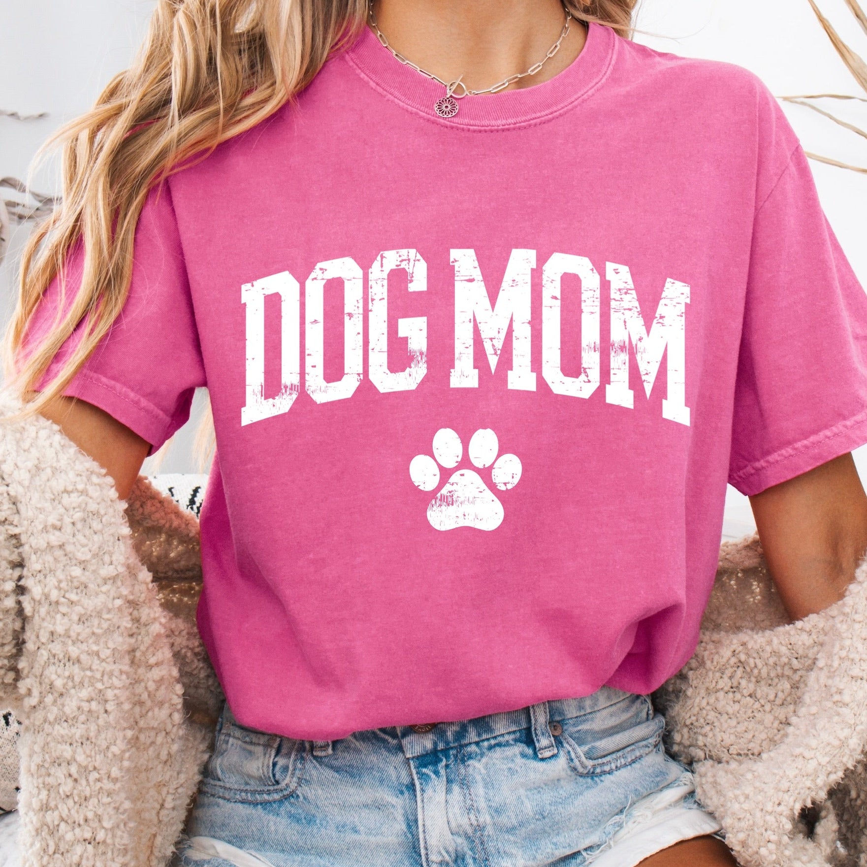 Person wearing a pink 'DOG MOM' t-shirt with a paw print design.