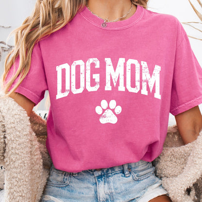 Person wearing a pink 'DOG MOM' t-shirt with a paw print design.