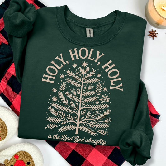 Green sweatshirt with 'HOLY, HOLY, HOLY' text and tree design on a white background with plaid fabric and rooster decor.