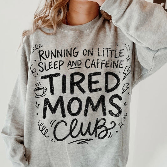 Gray sweatshirt with 'TIRED MOMS CLUB' text and graphics on a plain background