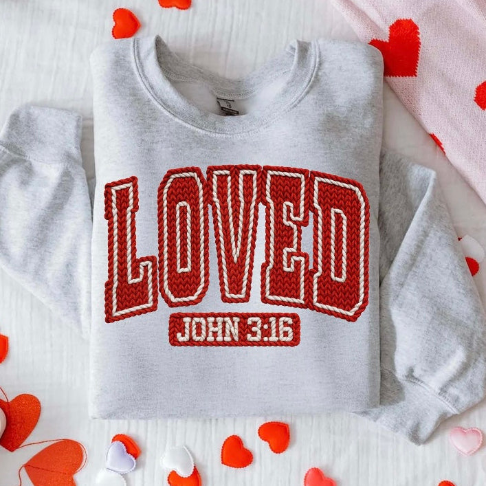 Gray sweatshirt with 'LOVED JOHN 3:16' text on a white surface with heart decorations.