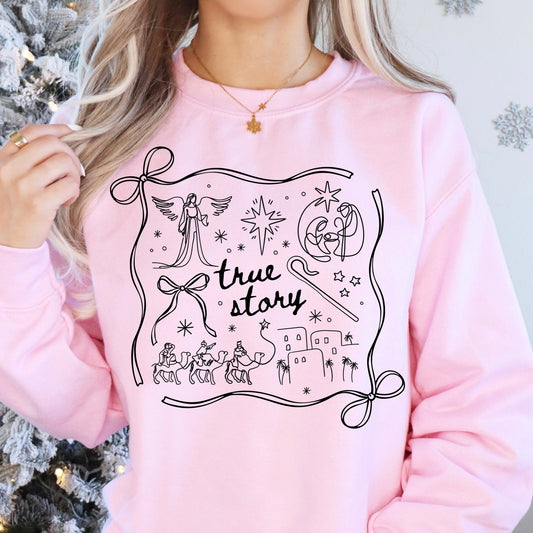 Person wearing a pink sweatshirt with a Christmas-themed design in front of a decorated tree.