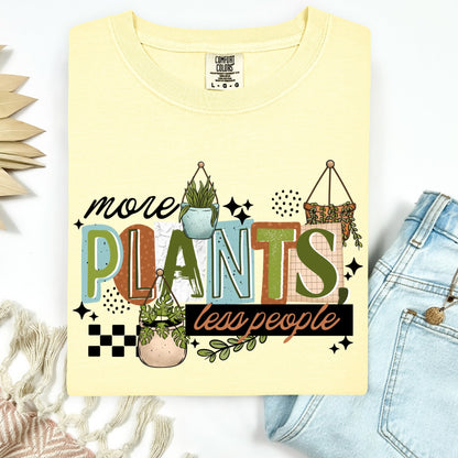 Yellow t-shirt with 'more plants less people' text and plant graphics on a white background.