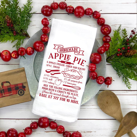 A screen print transfer with a vintage style recipe text for baking an apple pie, displayed on a white surface surrounded by red berries and baking utensils.