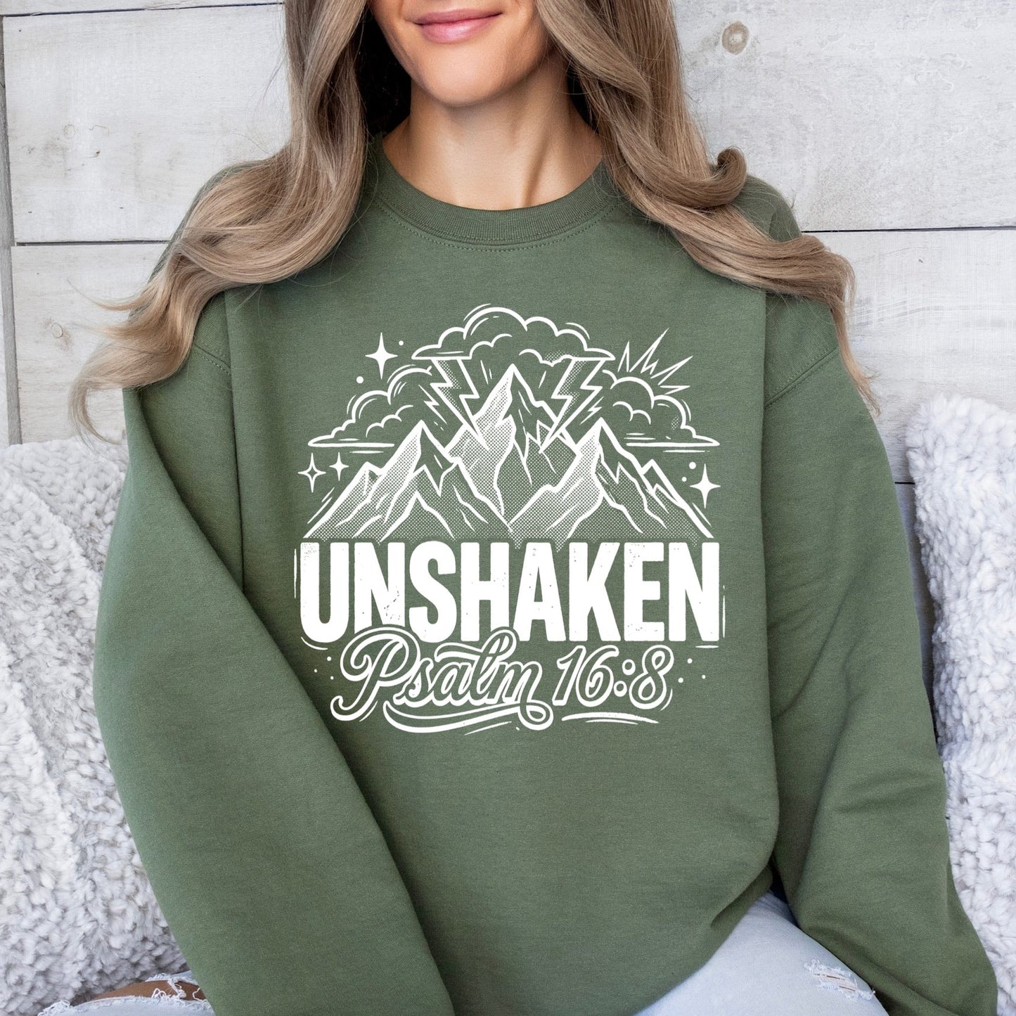Person wearing a green sweatshirt with mountain design and 'Unshaken Psalm 16:8' text.
