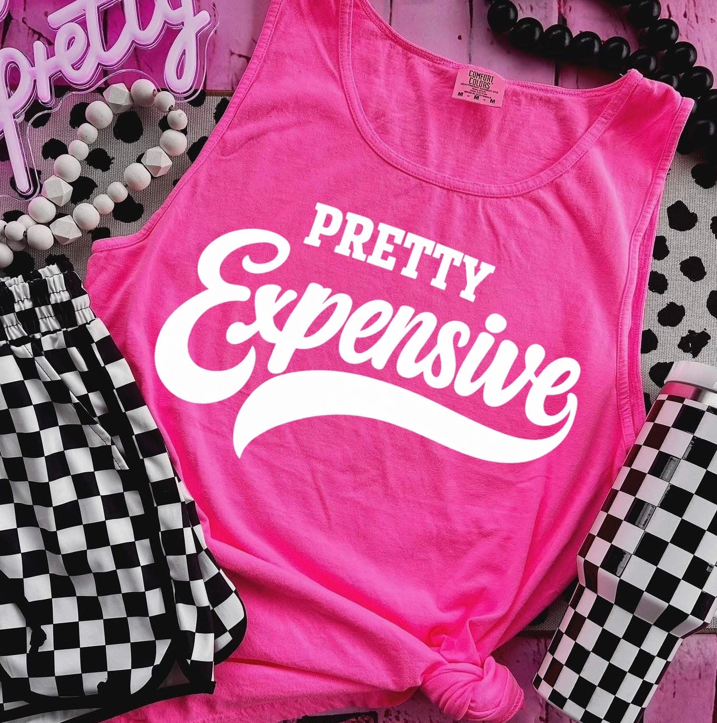 Pink tank top with 'Pretty Expensive' text on a checkered background