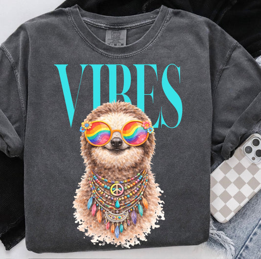 Gray sweatshirt with a sloth graphic and 'Vibes' text, displayed with jeans and a phone.