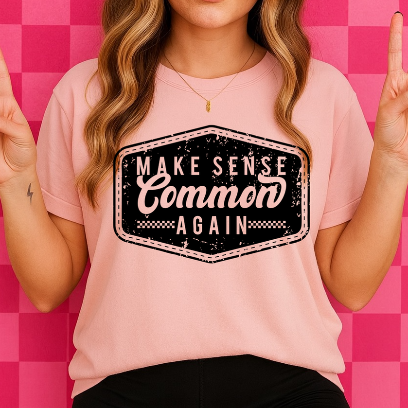 Person wearing a pink t-shirt with a graphic design on a pink checkered background