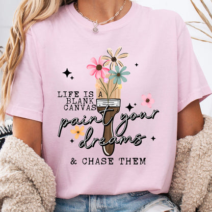 Person wearing a pink t-shirt with a motivational quote and graphic design.