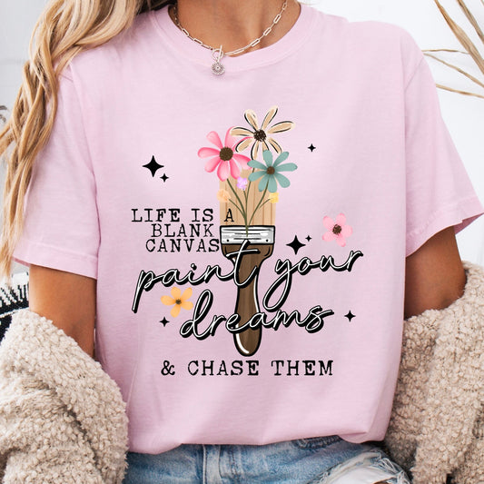 Person wearing a pink t-shirt with a motivational quote and graphic design.