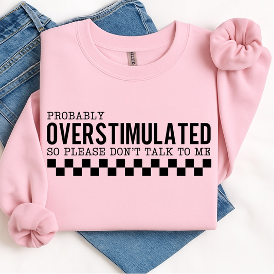 Pink sweatshirt with text 'PROBABLY OVERSTIMULATED SO PLEASE DON'T TALK TO ME' on a white background