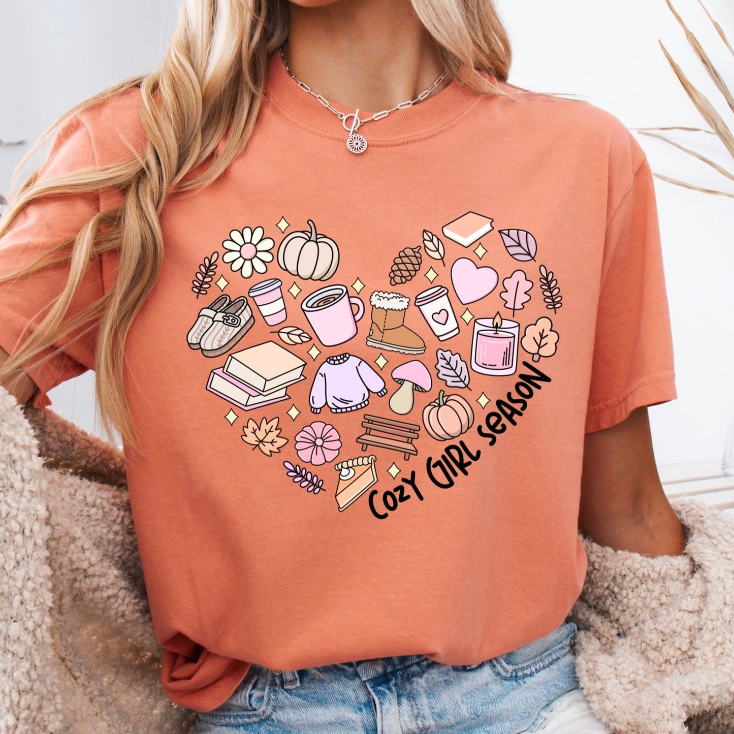 Person wearing an orange t-shirt with a heart design and text, sitting on a couchcozy girl season clear film transfer