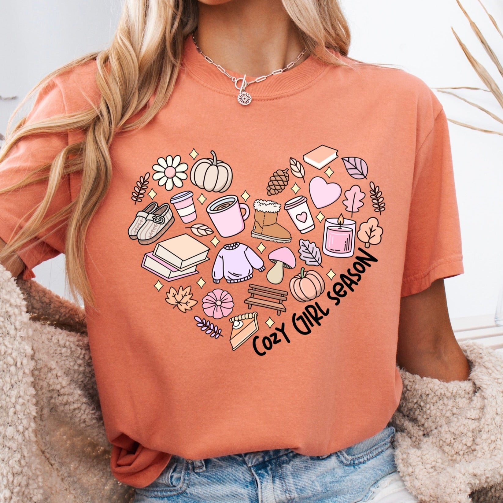 Person wearing an orange t-shirt with a heart design and text, sitting on a couchcozy girl season clear film transfer