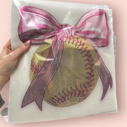 Decorative patch with a softball design and pink bow on a clear background