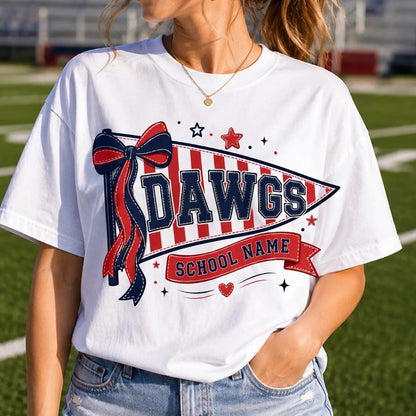 A woman wearing a white graphic t-shirt with a red and navy blue 'Dawgs School Name' design on a green football field background.